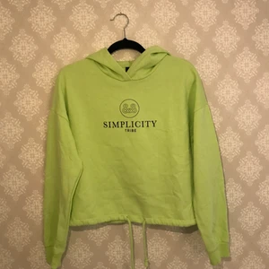 Limegrön hoodie/tröja - En limegrön/neongrön hoodie/tröja som använts endast ett fåtal gånger. Snörning längst ner för att kunna dra åt i midjan. Croppad längd. Mjuk insida. Text över bröstet. 💚 Hör av dig om du har någon fundering!!
