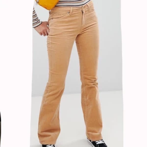 Micro Manchester byxor från monki 42 - Sköna stretchiga byxor från monki, lite låga i midjan. Använda ca 2 gånger. Nyskick. Färgen syns dåligt på bilden men har en mer mörk senaps gul/brun färg. Köparen står för frakt! 