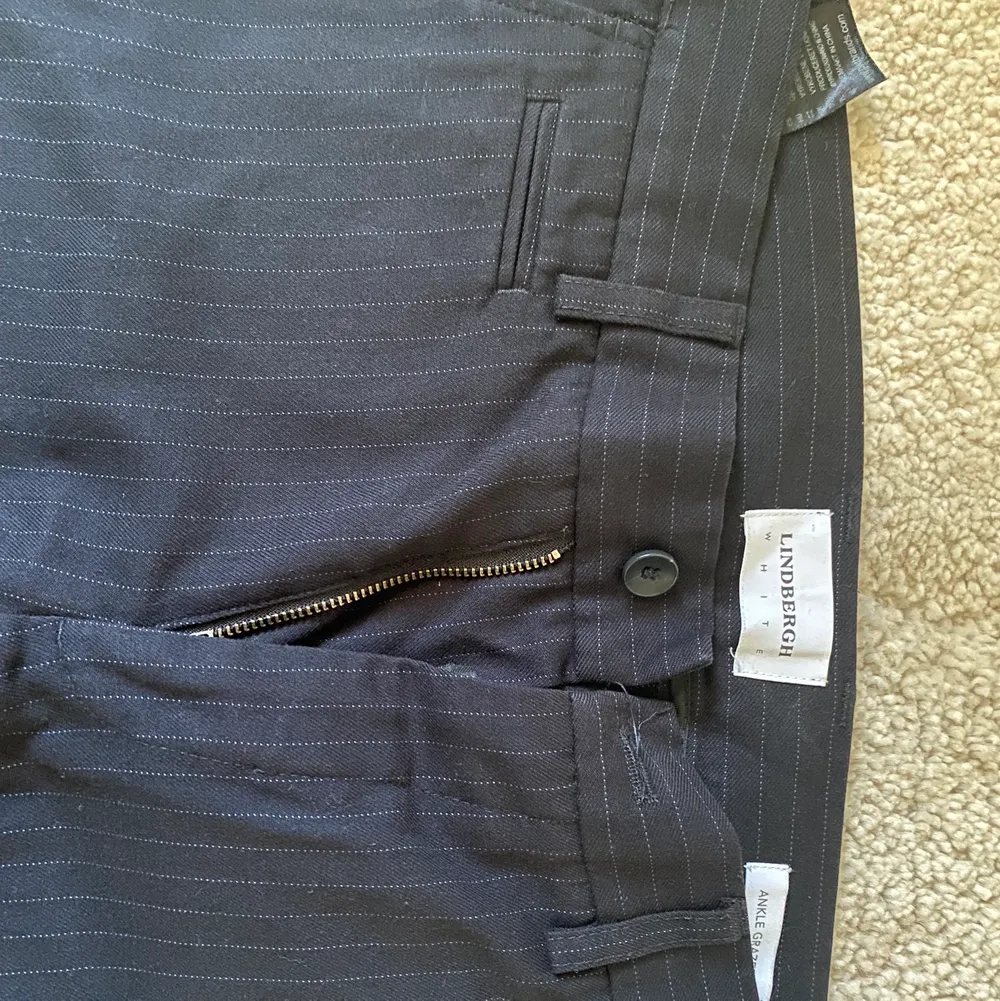 Ett par marinblå kostymbyxor med små vita streck längs med byxan. Knappt använda . Jeans & Byxor.