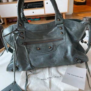 Balenciagaväska - Säljer nu min gråblå balenciagaväska köpt på The Vintage Bar i höstas där den gått igenom äkthetskontroll (se sista bilden). Den är i bra skick. Skriv vid intresse eller för fler bilder. Har bud på 5500, köp direkt för 6000💕