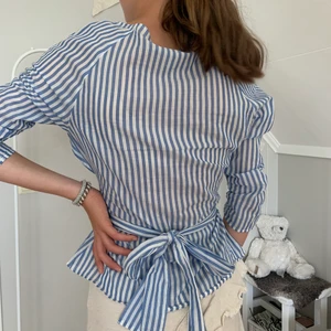 Söt tröja med volanger  - Bandet kan användas och knytas på olika sätt för att få flera olika utseenden på tröjan.