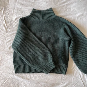 Stickad tjocktröja  - En underbar stickat tjocktröja i mörkgrönt. Det finns en härlig krage som värmer upp mot halsen men som absolut inte sitter hårt! ❤️