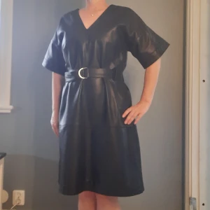 Klänning i lammnappa från Inwear! - En riktig powerklänning i skinn, helfodrad, tillhörande bälte. Väldigt snygg med polo under och svarta strumpbyxor... Nypris 2499:- 