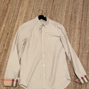 Burberry Skjorta - Beige Burberry i strl M. Inga skador, förutom en liten fläck nere vid ryggen, går säkert bort, har ej försökt.
