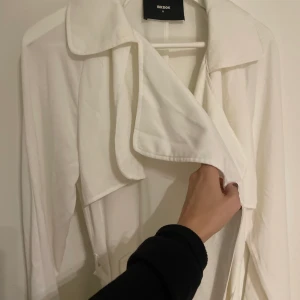 Trenchcoat  - Sjukt snygg vit trenchcoat från bikbok svår att visa på bild men är längre och med knytning och detaljer upptill