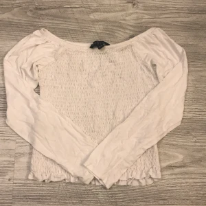 Vit topp - En vit fin topp med tunna armar. Sitter tajt runt brösten och magen.