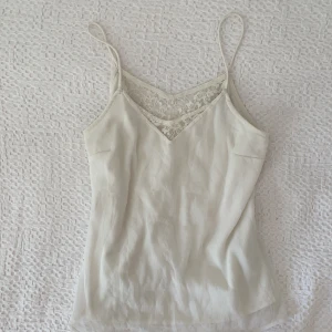 Vitt linne med spetsdetaljer - Säljer detta superfina vita linne som har lite spetsdetaljer i ryggen! Det är från Veromoda i storlek M och använt några få gånger, i bra skick🤍🤍