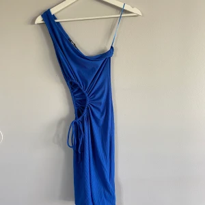 Blå klänning  - En blå klänning som är öppen på högersidan. Aldrig använd 
