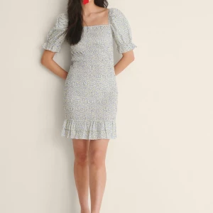 Blå blommig klänning  - Väldigt söt blå klänning från NA-KD i storlek S, helt ny även prislappen finns kvar.💞går även att göra den till off shoulder på armarna