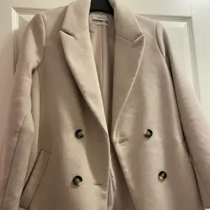 Oanvänd kappa i nytt skick i grå/beige färg. Storlek 38 för 600kr 