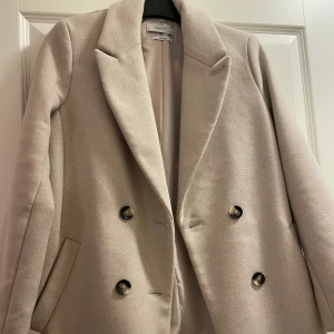 Kappa  - Oanvänd kappa i nytt skick i grå/beige färg. Storlek 38 för 600kr 