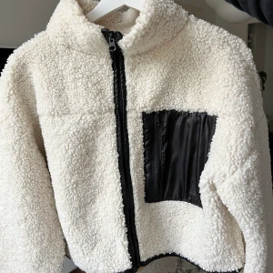 Vit teddy jacka - Säljer min söta vita Teddy jacka som är croppad från Gina Tricot.🥰 Jackan säljs inte längre på hemsidan. Den är i stl XS men är oversized så jag skulle säga att den passar en S-M, den är i ett mycket bra skick!! Kan skicka mer bilder privat!💖