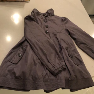 Jacka 134/140 - Grå ganska lång jacka i storlek 134/140.