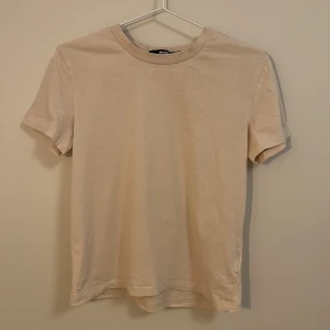 Gullig formnära t-shirt - BikBok. Supersöt liten t-shirt som sitter figurnära och är lagom lång. Inte magtröja men inte heller för lång. 