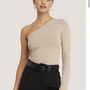One shoulder top - Topp från na-kd, i storlek XS. Material är bomull och elastan. Lite mörkare beige i verkligheten än på bild. Oanvänd!