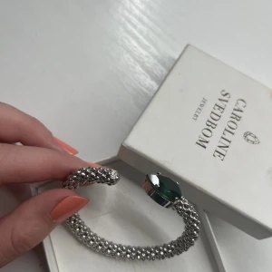 Caroline svedbom - Säljer nu mitt fina Caroline Svedbom armband! Köpte ca 5 månader sedan men jag har aldrig använt det då jag personligen använder mest guld smycken. Köpt för 900kr!💗stenen är grön och skimrar jättefint i solljus💖