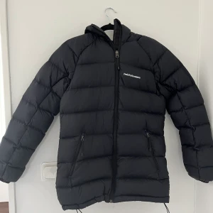 Peak Performance jacka - Stilren, mångsidig och sportig dunjacka fodrad med värmande dun och vattenavvisande yttertyg. Fickor med dragkedja för säker förvaring. Huvan ger skydd mot snö och vind. W Ilma DJ Både killar o tjejer kan använda den. Mycket fint skick!