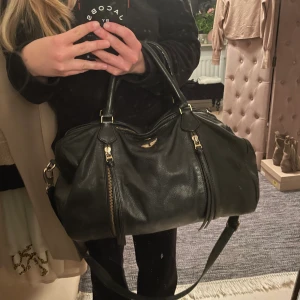 Zadig Voltaire Väska - Säljer nu min superfina Zadig Voltaire väska i storleken medium. Superfint skick inga tydliga defekter sparsamt använd. Bra med utrymme och du får ner allt du behöver. Väskan har två handtag samt en avtagbar rem. Frakten ingår i priset. Pruta kan man! 