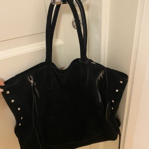 Väska i mocka (läder) och silvernitar - Kollar intresset på denna såå fina handväskan i svart mocka med silvriga nitar och detaljer💗💗 Den har aldrig blivit använd då jag har för många väskor, så den är helt i nyskick 😊Liknar lite zadigväskorna🥰 Köpt för 1300kr