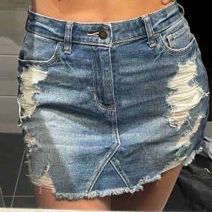 Hollister Hige-rise skirt - En väldigt fin jeanskjol som har slitningar fram. Den är i storlek w26 (passar en S). Säljs då den inte används, den är i bra skick.