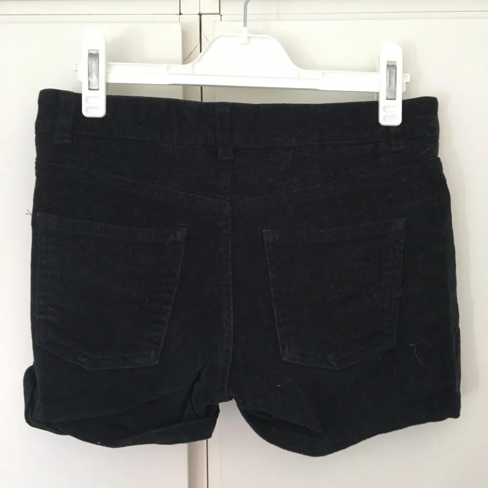 Korta svarta manchestershorts med fickor fram och bak. Guldknappar. Från H&M. Storlek 32.. Shorts.