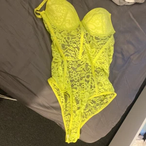 Neon body - Oanvänd boddy då jag inte fick på mej så då lossnade bakre nypan kan skicka bild:) neon gul storlek M men känns som S