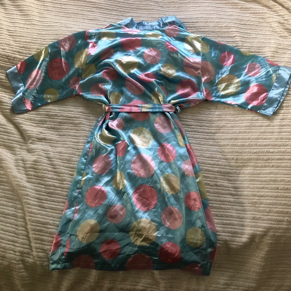 Det här är en supersnygg unik morgonrock som även går att styla upp och ha som en snyggklänning eller till halloween klädsel. Väldigt 70tals inspirerad med snygga pastellfärger och i silk.. Klänningar.