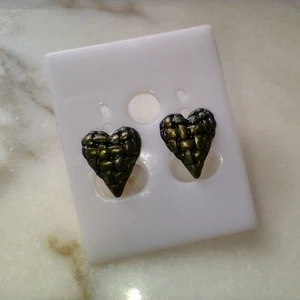 Hjärtformade, mässingsfärgade örhängen i metall - Hjärtformade örhängen i metall. Mässingsfärgade. Ca 13 mm långa. Fraktpris 15 kr. 