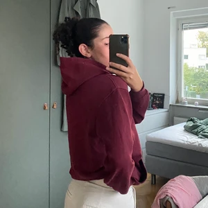 Vinröd hoodie  - Vinröd hoodie med liten text på framsida. Använt mycket för träning men också ute. Bekväm och värmande, dock är ärmarna lite för kort för mina armar, vilket är anledning till att jag säljer.