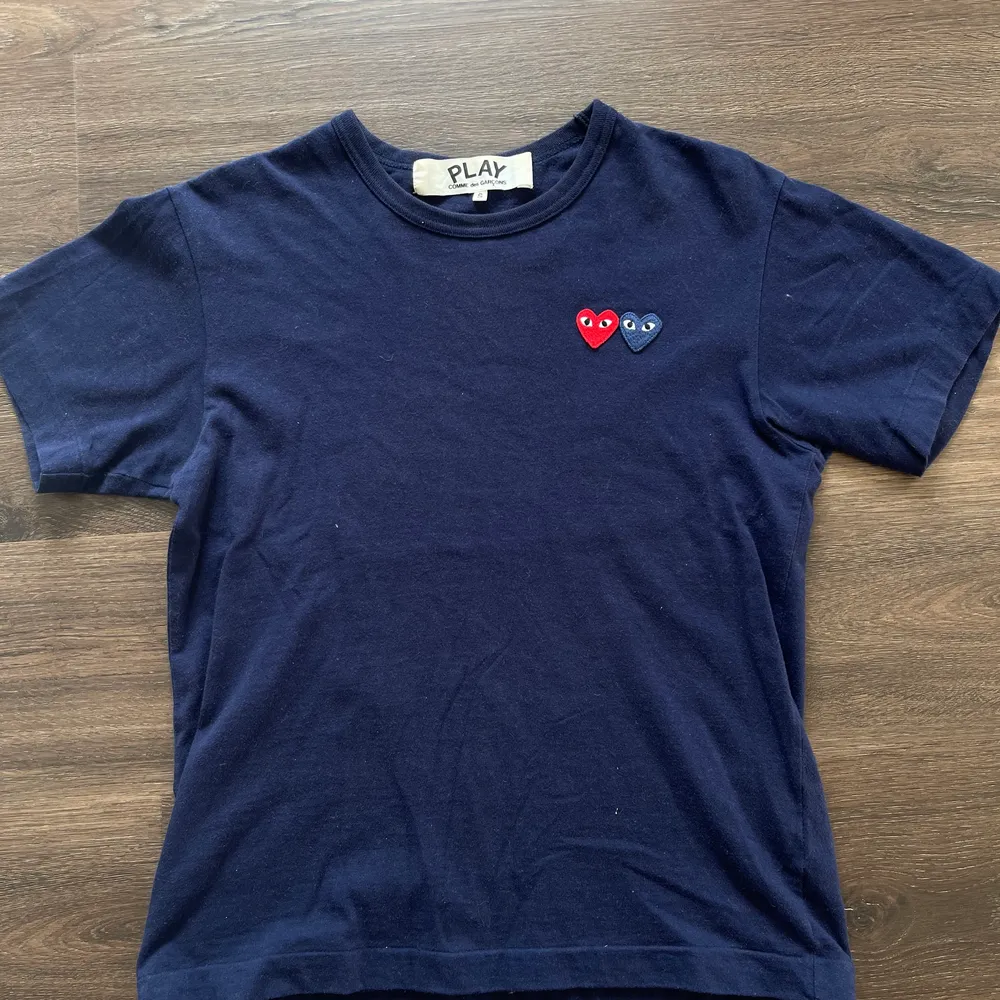 Marinblå T-shirt från play Comme des Garcons. Köpt i London. Kvitto finns. Nyskick  Nypris är 1000kr. T-shirts.