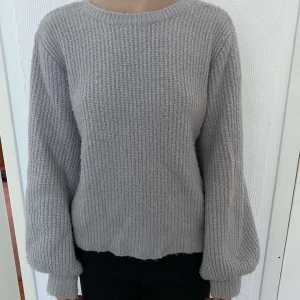Stickad tröja - Grå stickad tröja i strl xxs från Linn Ahlborgs kollektion på NA-KD. Ganska stor och kan användas åt båda håll beroende på vilken urrigning man vill ha! 