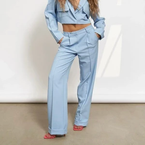 Byxor - Blåa kostymbyxor ifrån hanna schönbergs kollektion på NA-KD i storlek 36.