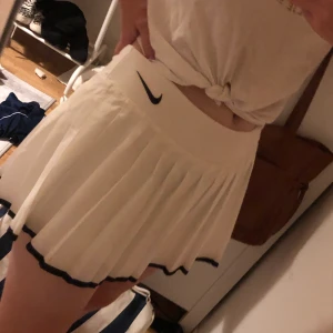 Tennis kjol - Tennis kjol i ett mycket bra skick, endast använd 2-3 gånger. (Från Nike) ”Cykelbyxor” sitter fast i kjolen. Startbudet är 100 kr. Kjolen är i storlek ”barn XL” men den sitter bra på mig som har dam M i de flesta kjolarna.