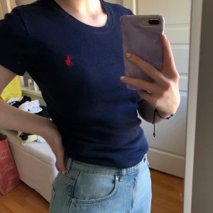 Ralph Lauren t-shirt  - En snygg och skön mörkblå t-shirt med ett rött Ralph Lauren märke på högra sidan av tröjan✨ Tröjan är som sagt från Ralph Lauren och i stl S💕 Köparen står för frakten! 💋