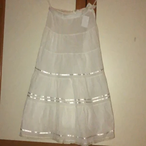 Lång vit kjol - SUPERFIN lång vit kjol. Den är köp secondhand men är i väldigt bra skick. Aldrig använd då den inte passar. Skulle säga att den passar någon som är S/M. Den är inte genomskinlig men inte speciellt. Lappen är fortfarande på och säljer den för samma pris.