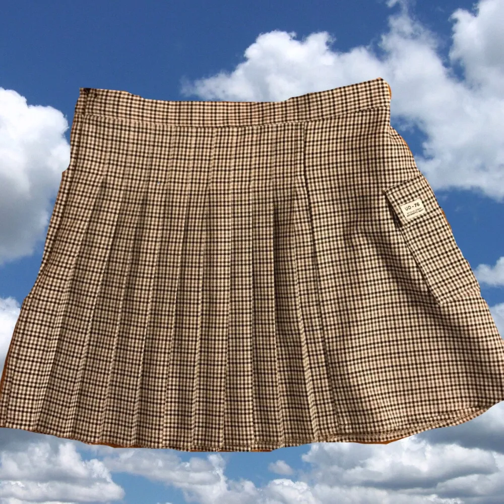 Rutig kjol med pleats på hälften av kjolen och sedan ”platt tyg hälften. Har en liten ficka på sidan, även dragkedja på andra sidan. Köpt förra sommaren. Kjolar.