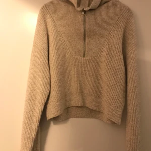 Stickad tröja med zip  - Stickad tröja med zip ifrån H&M. Beigemelerad, endast provad. 100kr plus frakt som köparen betalar. 