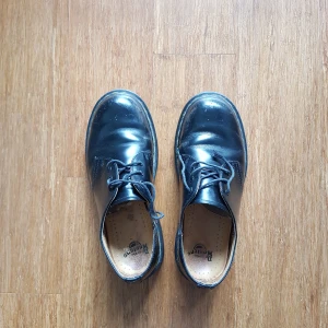 Låga Dr. Martens kängor - Dr. Martens- kängor i låg modell och gott skick. Ena skosnöret har gått av och är därför kortare. Storlek 37 (US 6). Möts upp i GBG eller fraktar mot betalning.