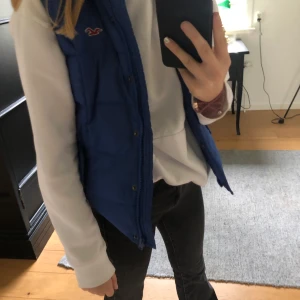 Hollister väst storlek S - En marinblå väst, går inte över rumpan så är en perfekt längd. Den är aldrig använd så skicket är väldigt bra!   Nypris 800kr, mitt pris 350kr & du som köpare står för frakt!