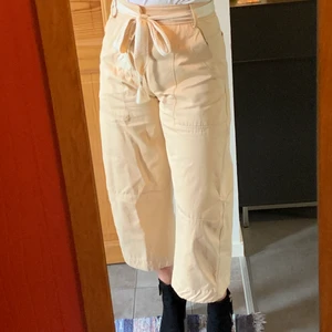 Beiga jeans - Säljer dessa cargo inspirerade byxorna från Zara! Har knappar vid gylfen och slutar ungefär 1dm ovanför ankeln🥰 (en knapp har lossnat i gylfen men det gör ingen skillnad!)