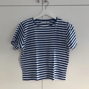 Randig T-shirt - Blå och -vitrandig t-shirt i storlek M. Lite stor i storlek skulle jag säga. Vidare armar än en ”vanlig” tight t-shirt