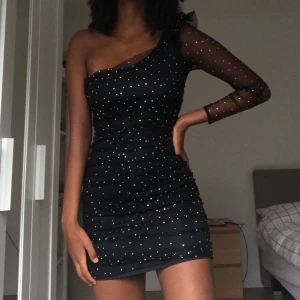 Festklänning  - En sjukt snygg svart klänning med glitter. Sitter som en smäck och är perfekt till nyår! Gillar speciellt detaljerna vid ena axeln :) Helt oanvänd från Zara (prislappen sitter fortfarande kvar). 