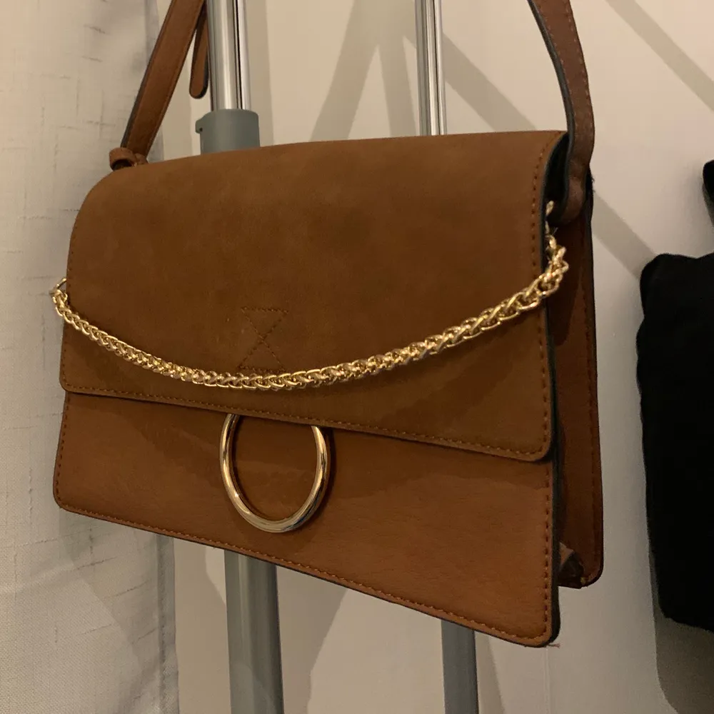 Mockaliknande brun väska från Forever 21, använd fåtal gånger i väldigt fint skick! Guldiga detaljer och justerbart band som även går o göra kortare/längre. . Väskor.