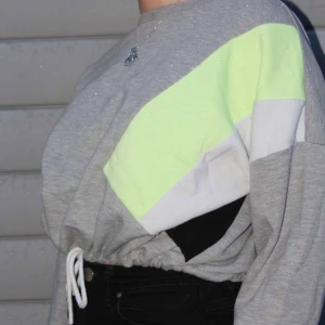 Grå/neon Sweatshirt - Säljer nu denna neon dröm som varken är för basic eller för mycket! Tröjan är i str M men om man vill att den sitter lite oversize skulle ja att den även passar som str S. I midjan finns ett snöre så man själv kan välja hur den ska sitta! Den är köpt i Italien på primark. Köparen står för frakt💞💞 (OBS dom vita prickarna är snö från fotograferingen)