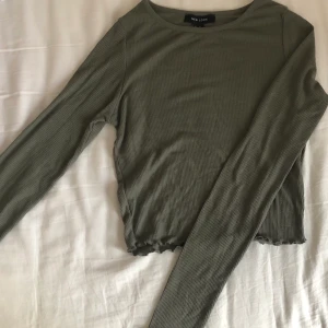 Olivgrön / mintgrön topp - En tröja köpt från new look i London. Den är använd några få gånger. Den är olivgrön o ribbad i storlek 38, passar XS-S! 
