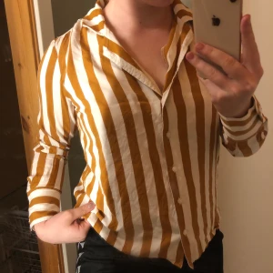 Randig skjorta  - Säljer min orange/vit randiga skjorta från bikbok som inte finns att köpa längre vad jag vet!          Använd två gånger:) storlek M men passar bra på S.    Köpt för 250 kr, säljer för 80 kr+ frakt.                     Säljer pga ingen användning 