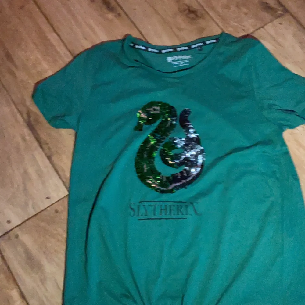 En snygg tröja med slytherin loggan på.. T-shirts.