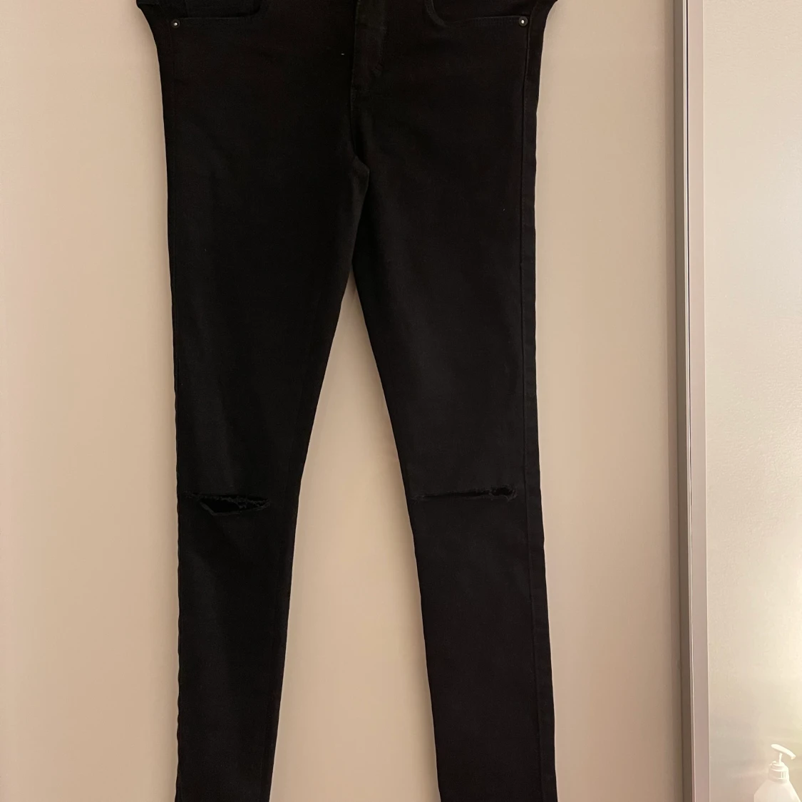 Svarta jeans från Only med hål på knäna.