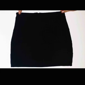  - Svart kjol med fräcka detaljer! Den är räfflad och har en silvrig dragkedja där bak. Väldigt bra skick! 