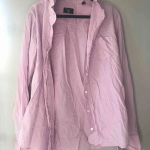  - Gant skjorta i lila/rosa. Har en ficka på höger bröst. Man kan ha den både stängd men också öppen. Det kan vara snygg på sommaren med en tröja under. 